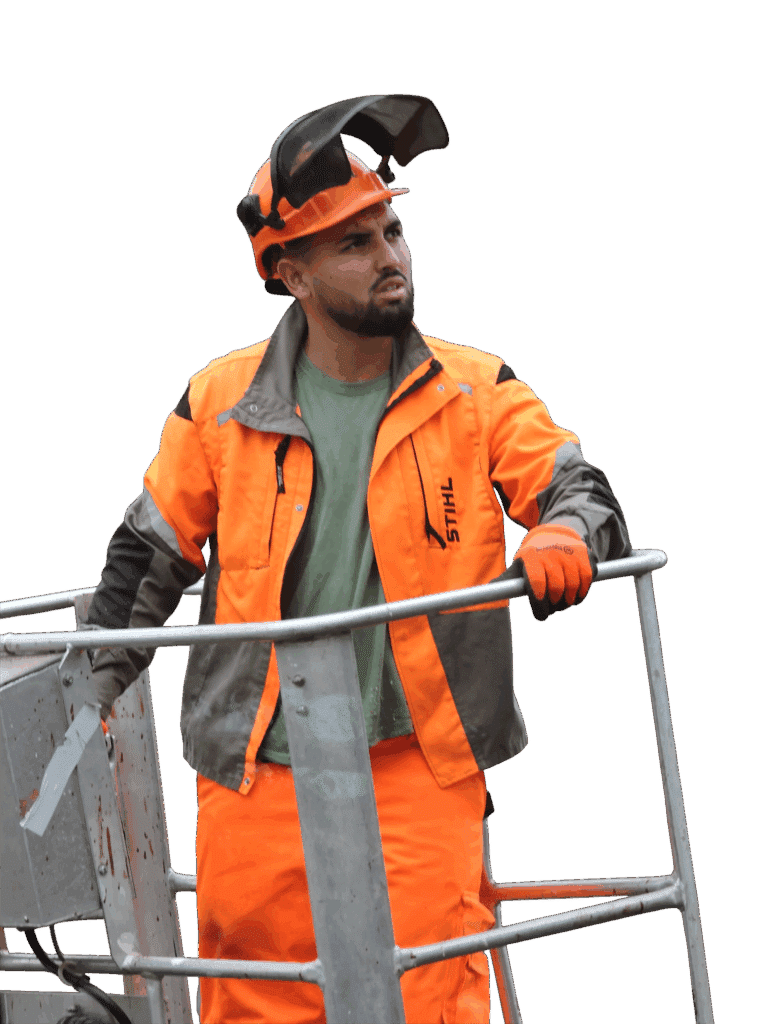 Bûcheron Stihl en nacelle : Sécurité et EPI orange. Bûcheron ou arboriste en tenue de sécurité orange Stihl et casque avec visière relevée, travaillant sur une plateforme élévatrice.